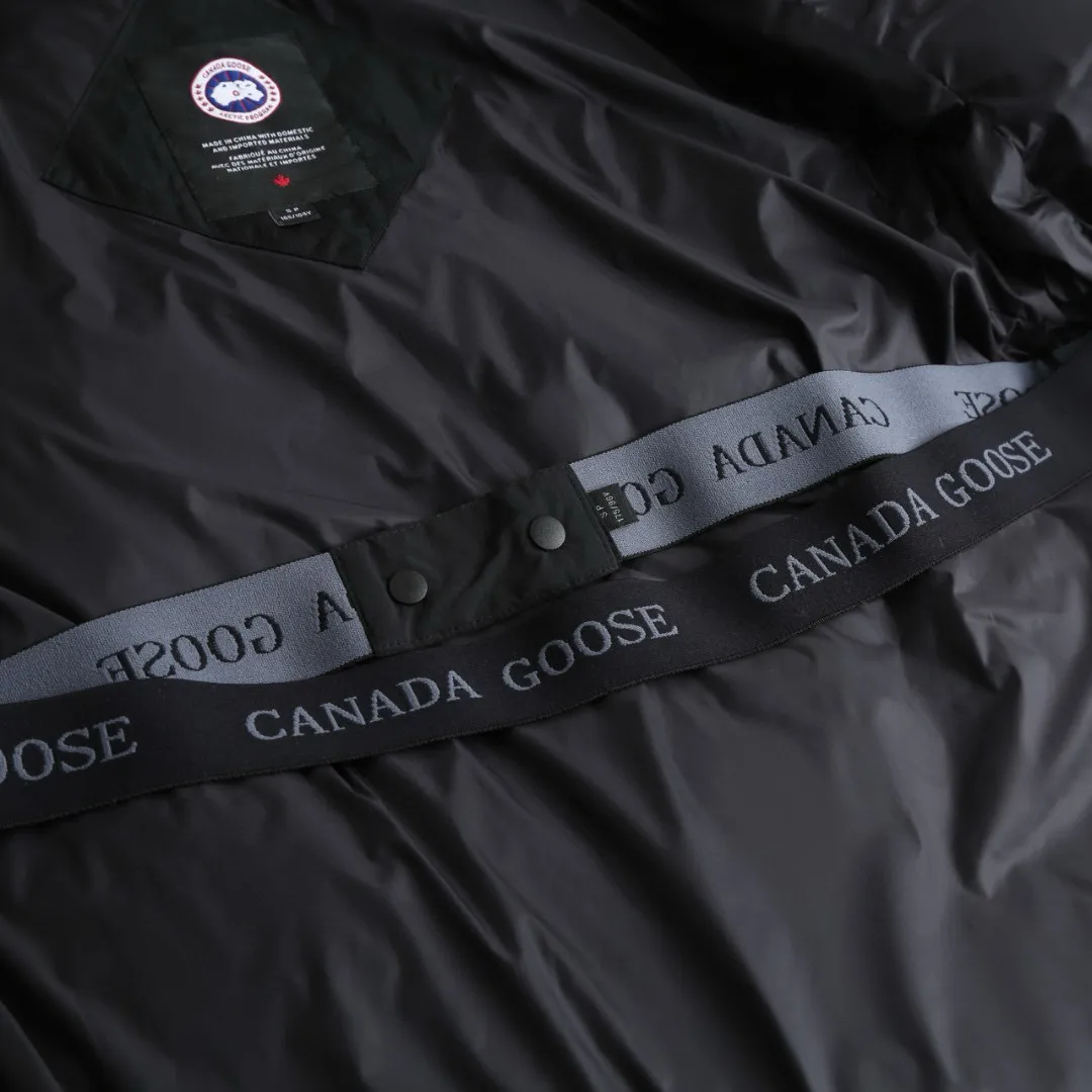 P1010 [Exclusive supply] Canada Goose Black Label Badge Hooded Down Jacket (Black) The high-quality filling is made of 90 national standard high-quality white duck down, selected high-loft velvet, weighing 240g, light and warm, with excellent temperature locking performance and good resilience. The fabric is woven with 400T high-count yarn. After special water-repellent treatment, the surface forms a lotus leaf effect - raindrops will slide down like beads, and snow particles will fall off when touched. The tear resistance reaches 200N (approximately 20kg load-bearing), the light gray matte texture breaks the stereotype of "outdoor clothing = hardcore", and the soft luster presents a high-end matte effect under urban neon lights, seamlessly switching scenes from ski resorts to CBD office buildings. The ribbon is woven with polyester as the base, and the brand letters are decorated on the ribbon through high-precision computer embroidery. The edges of the pattern are clear, the stitches are fine and even, and multiple layers of embroidery thread are stacked to enhance the three-dimensional effect. Precision thread reinforcement prevents linting and ensures the fluffy and resilient elasticity lasts as new. The embedded cuffs are three-dimensionally woven to form a "wavy" elastic structure, which forms natural folds when fitting the wrist, increasing the contact area with the skin, thus improving the windproof effect. At the same time, micro-velvet treatment is added to the inside of the cuffs, which feels like a second layer of skin and avoids friction on the skin from metal zippers or hard fabrics. Size:S-M-L-XL